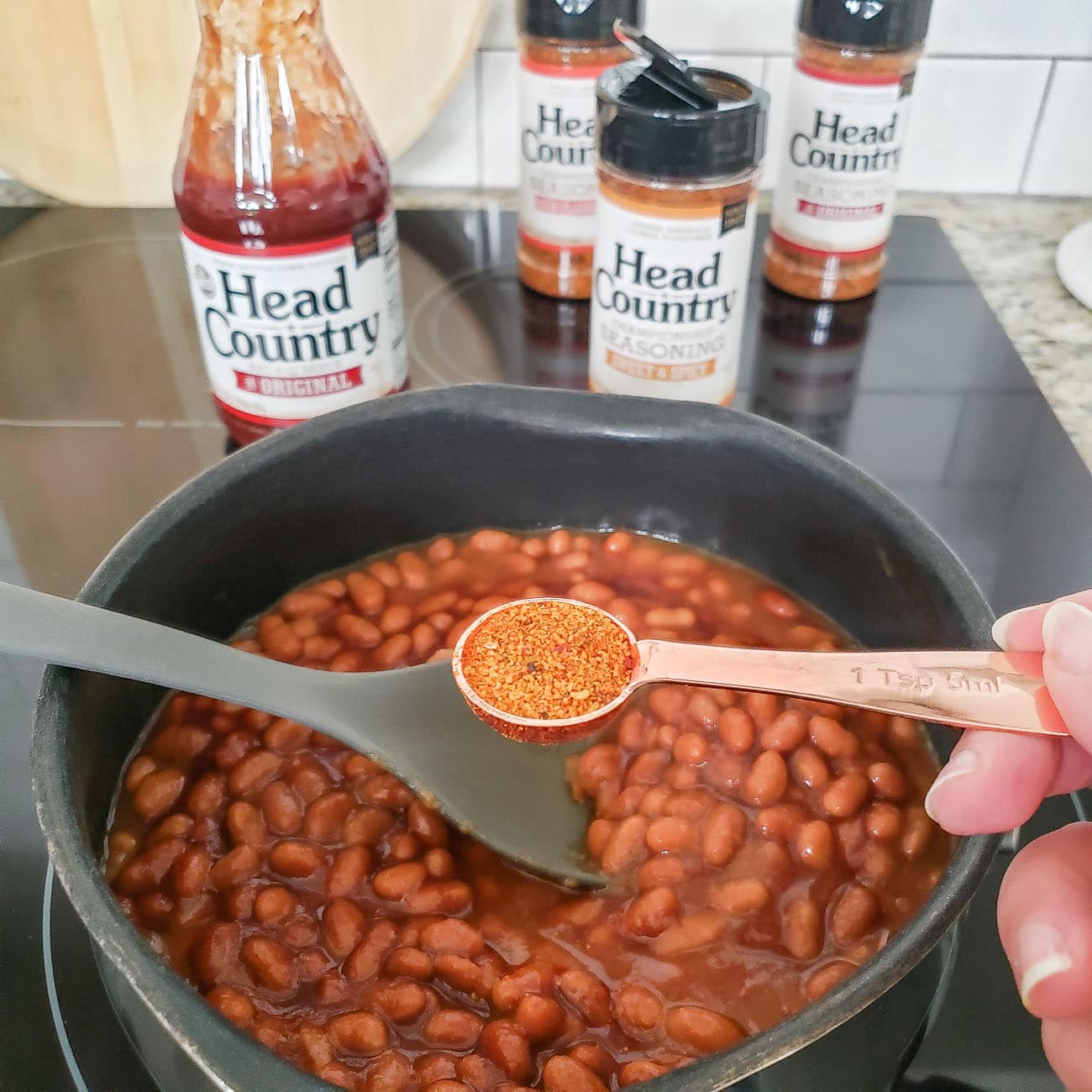 Head Country seasoning being added to baked beans